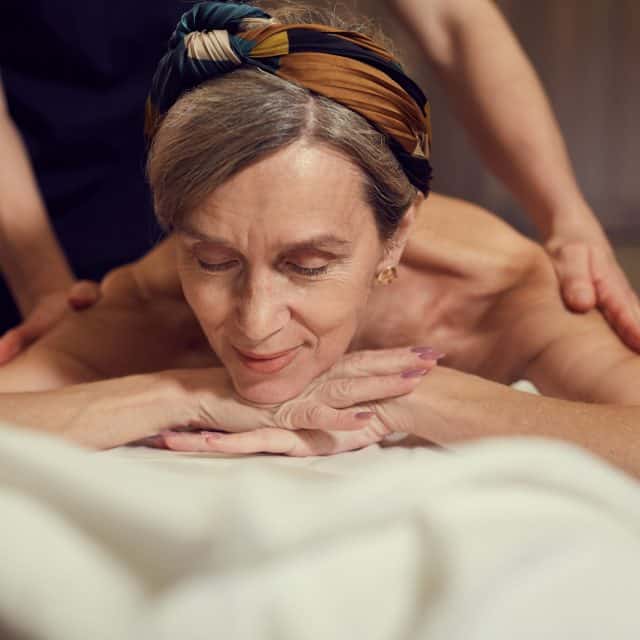 Smiling Senior Woman Enjoying Massage in SPA